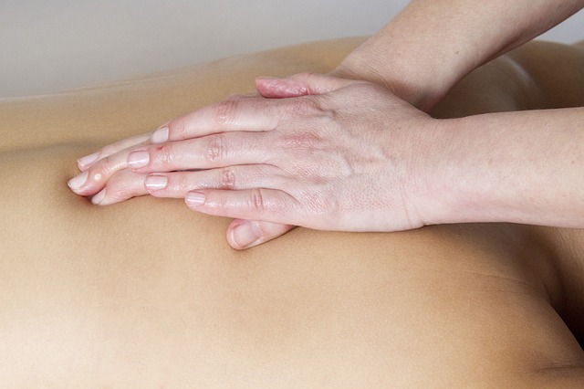 Personne qui pratique un massage sur un dos.