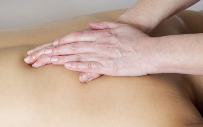 Personne qui pratique un massage sur un dos.